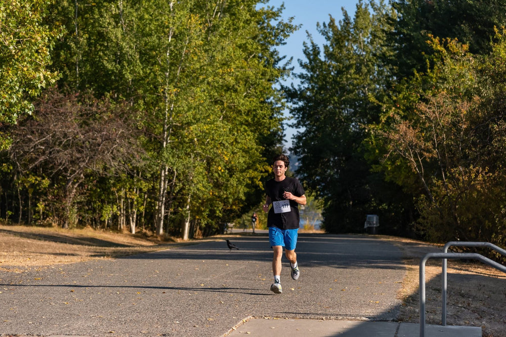 Distance runner training on a tree-lined road