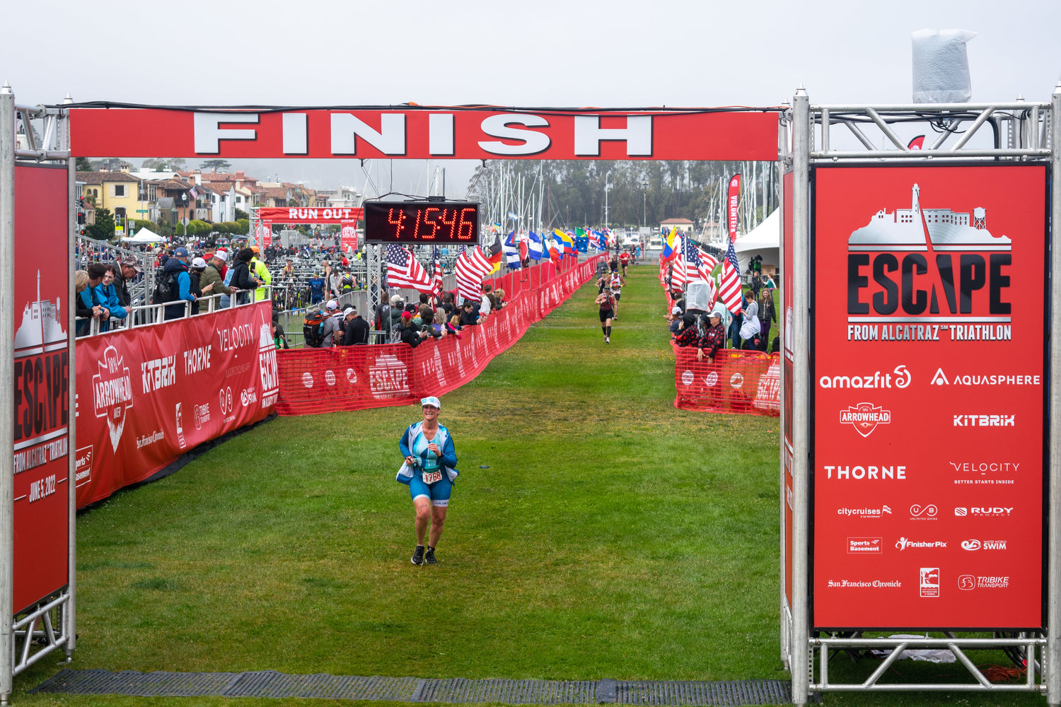Triathletes running toward a triathlon finish line