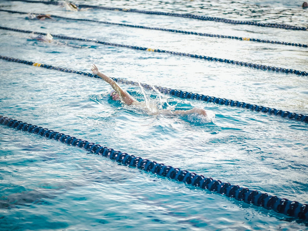Swimmer practicing freestyle technique in a marked lap pool