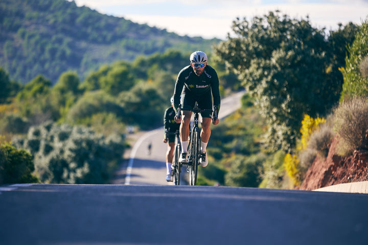 Road cyclist training uphill on a rural road for an average cycling speed guide