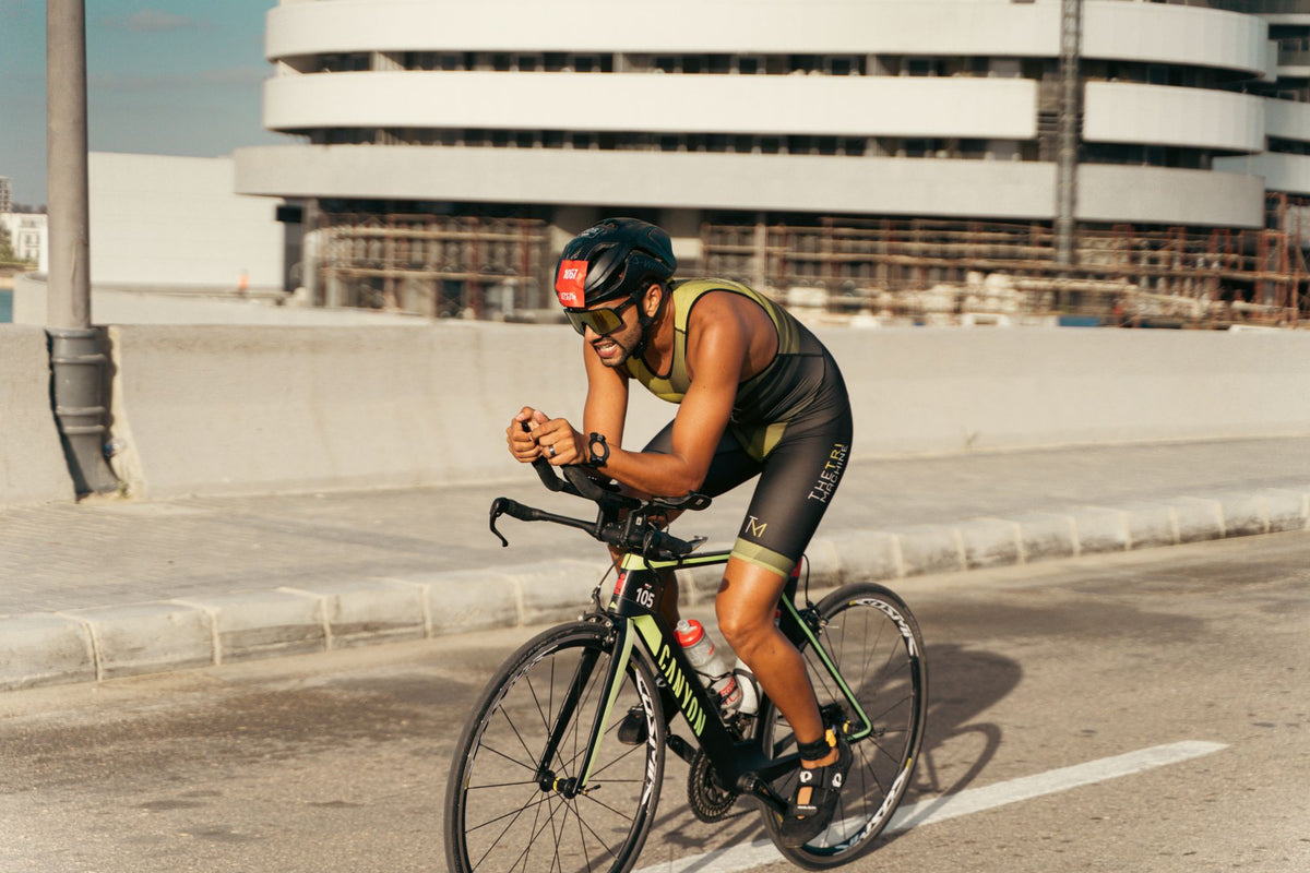 Triathlete riding a time-trial bike in an aero position during an urban race