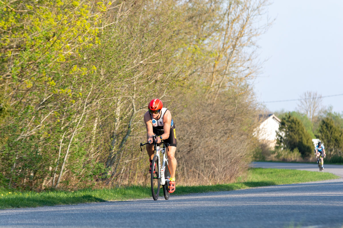 Triathlete cycling on a quiet road during aerobic base training