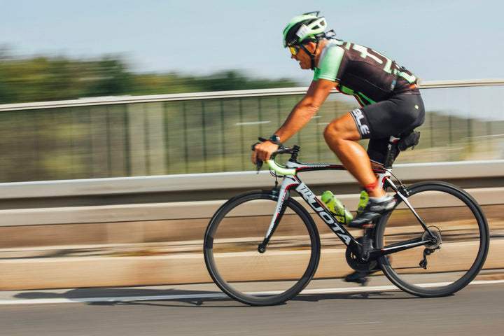 Triathlete riding a road bike during a triathlon race while choosing a first triathlon bike