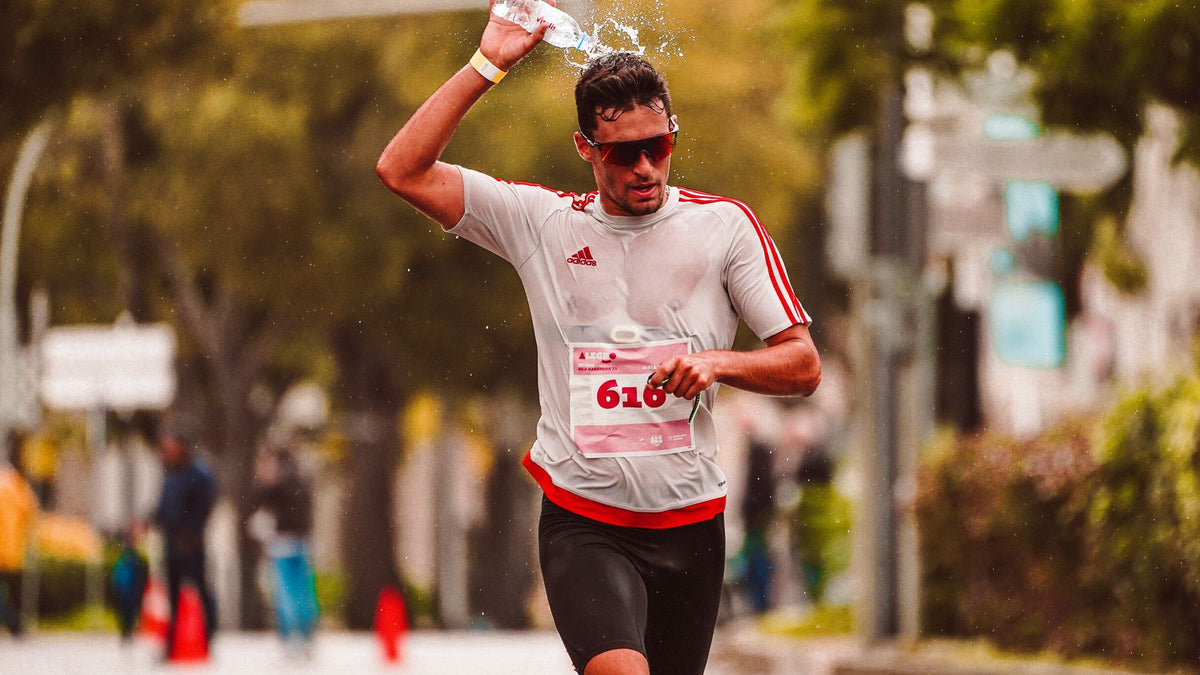 Marathon runner pouring water over his head in hot conditions