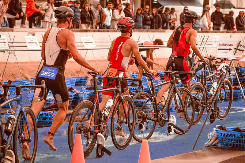 Triathletes moving through a bike transition area during a race